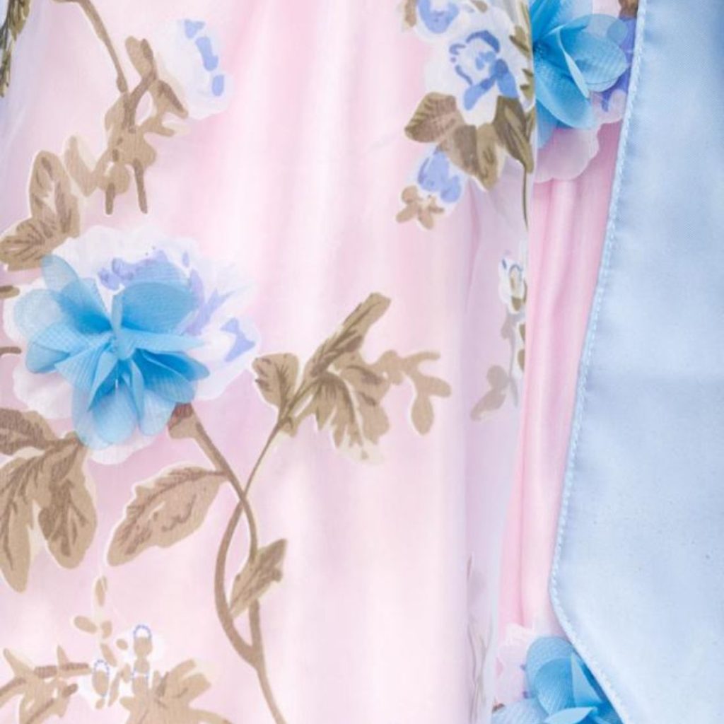 Die Schürze des Dirndls Rosè wird hier vergrößert angezeigt, die blauen Blumen sind aufgenäht.